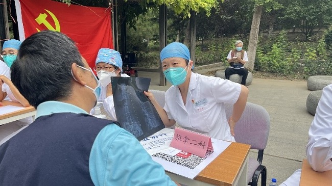 图为义诊现场主治专家为居民进行检诊